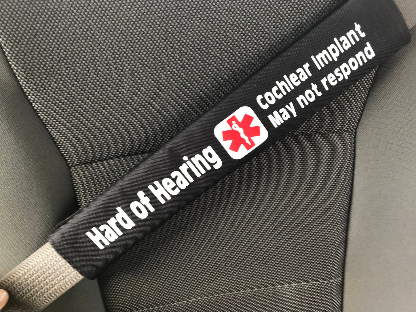 Black strap with medical warning label on a car seat