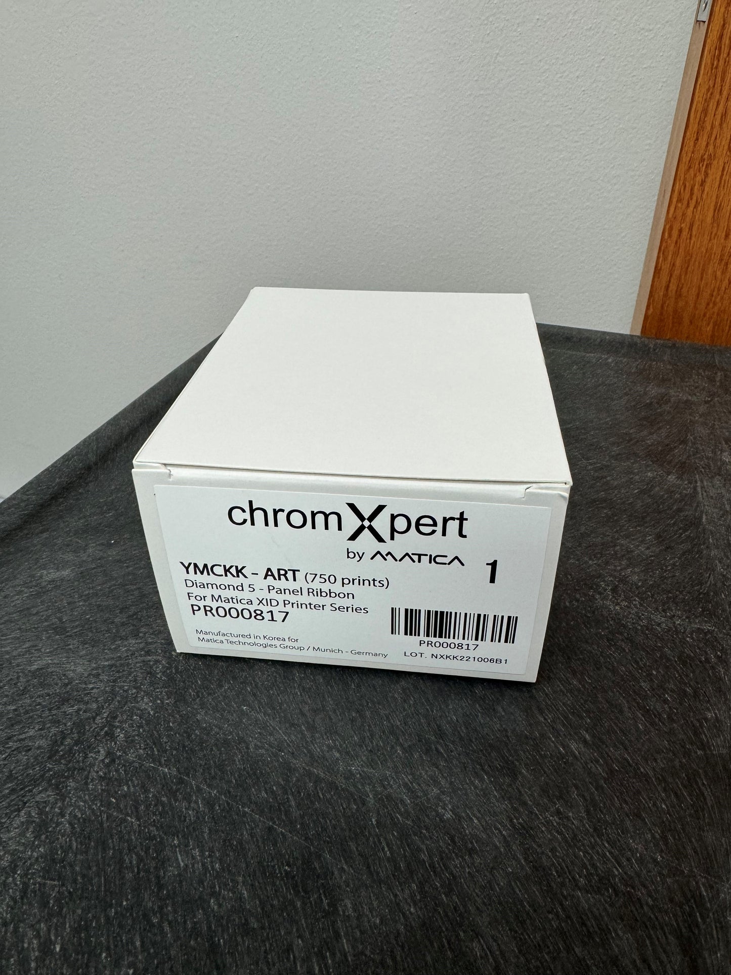 White box labeled 'chromXpert by Matica' on a dark surface with a neutral background